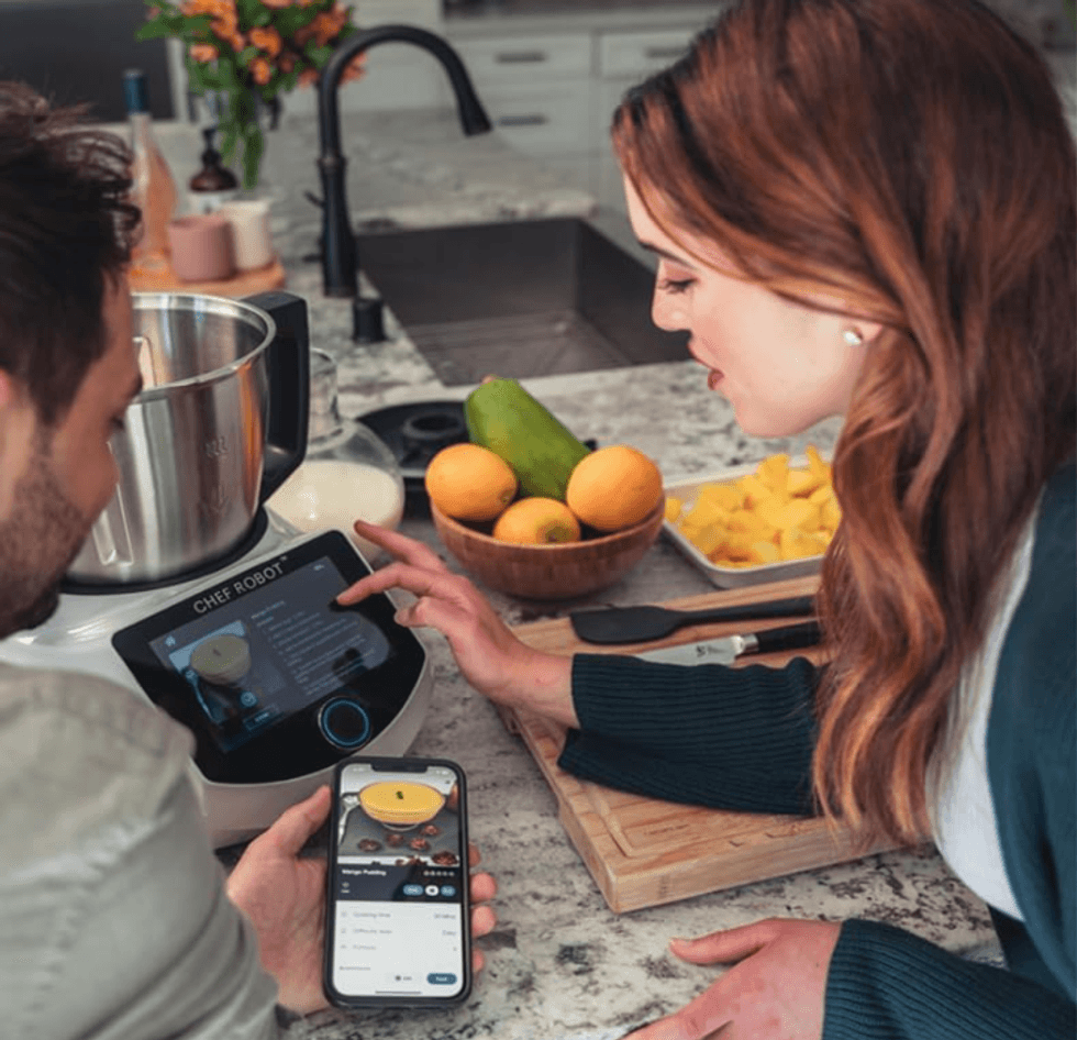 a couple using the smartscreen on ChefRobot Ultra Smart Food Processor and their smartphone.