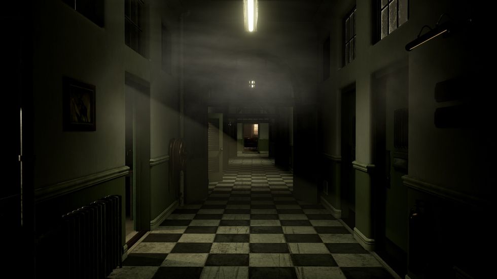 A dimly lit hospital hallway, which is empty with a checkerboard floor
