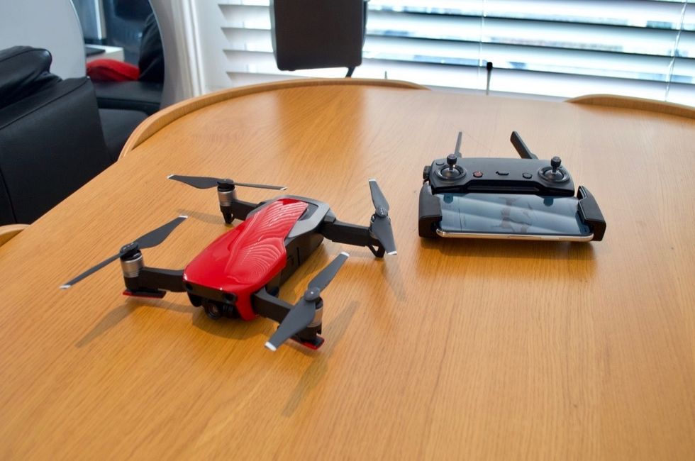 A DJI Mavic Air drone in red on top of a wooden table