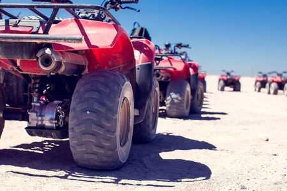 A group of quad bikes drive in the desert Stock Photo