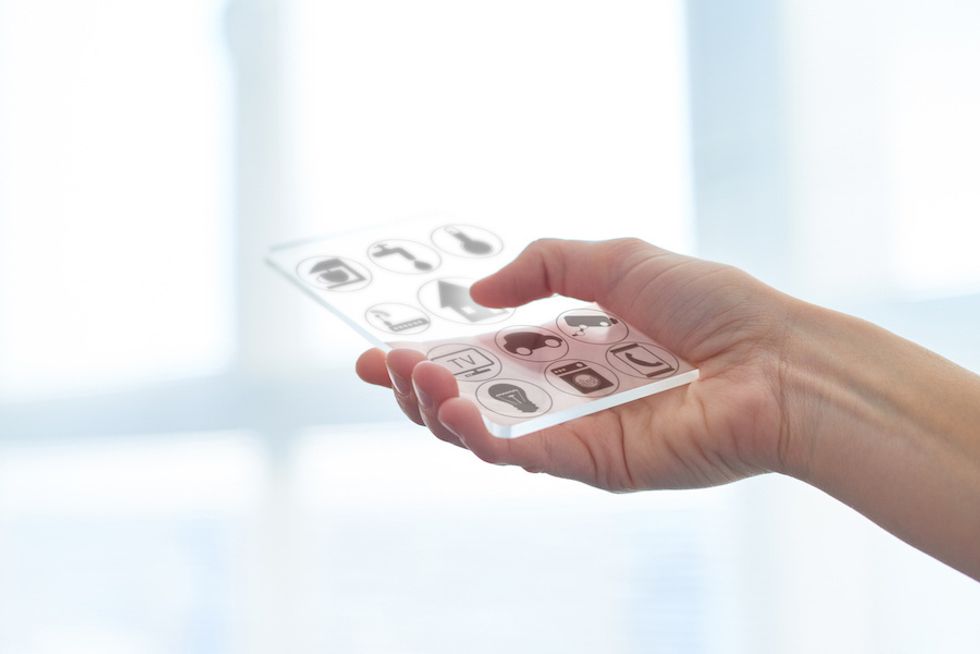 A hand holding a clear handheld device with images on them