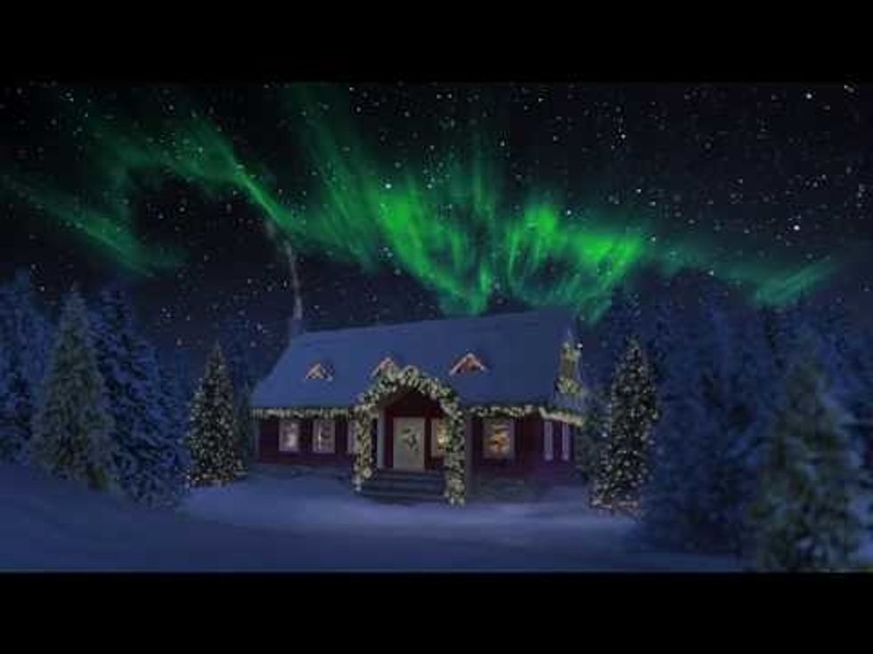 A house in the snow, surrounded by decorations