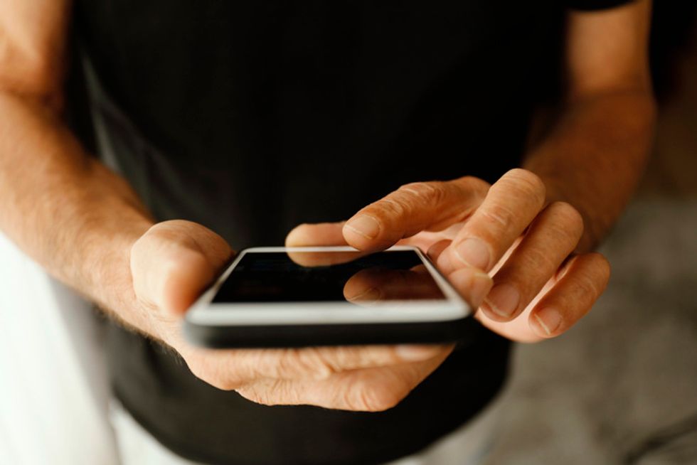 A man holding and working on a smartphone