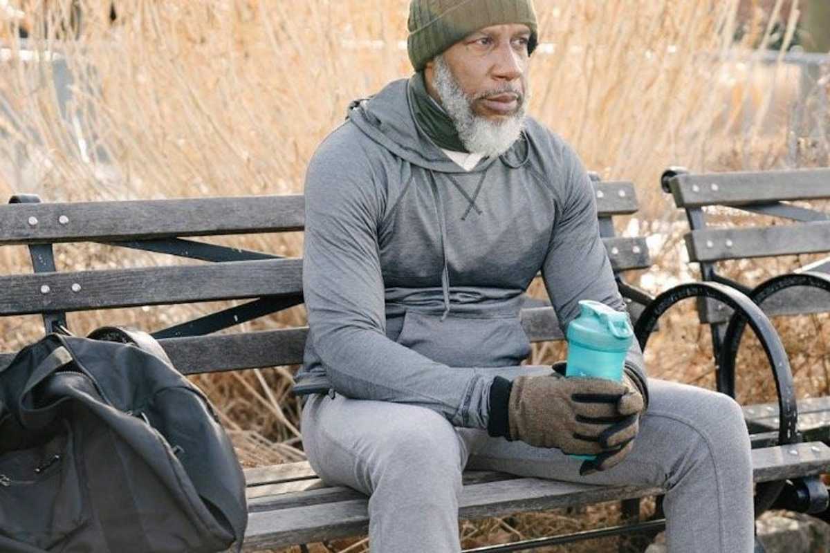 a man sitting on a bench with camping gear photo