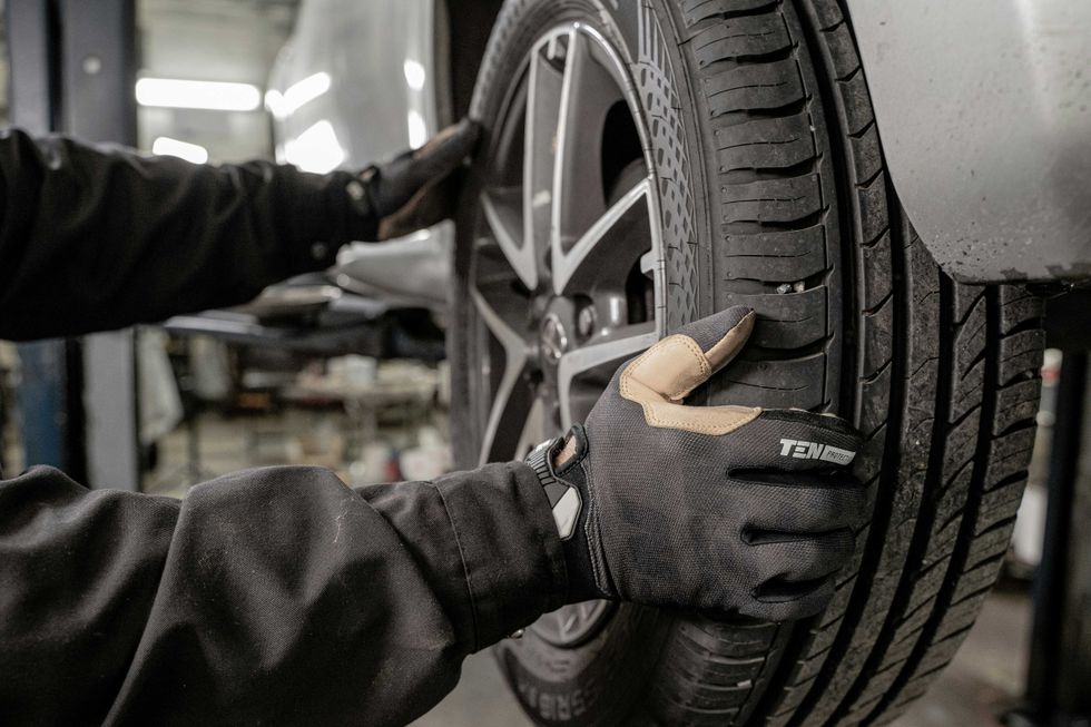 a man working on a tire in a garage photo