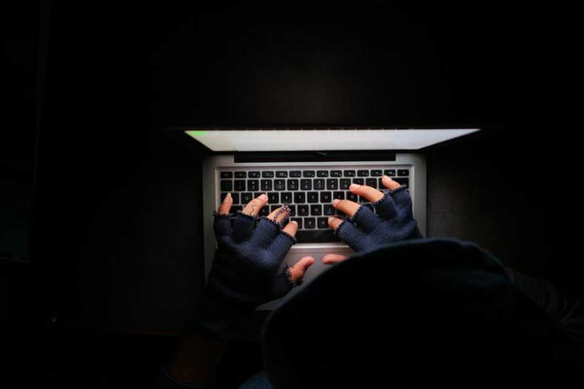 A pair of hands in gloves on a keyboard