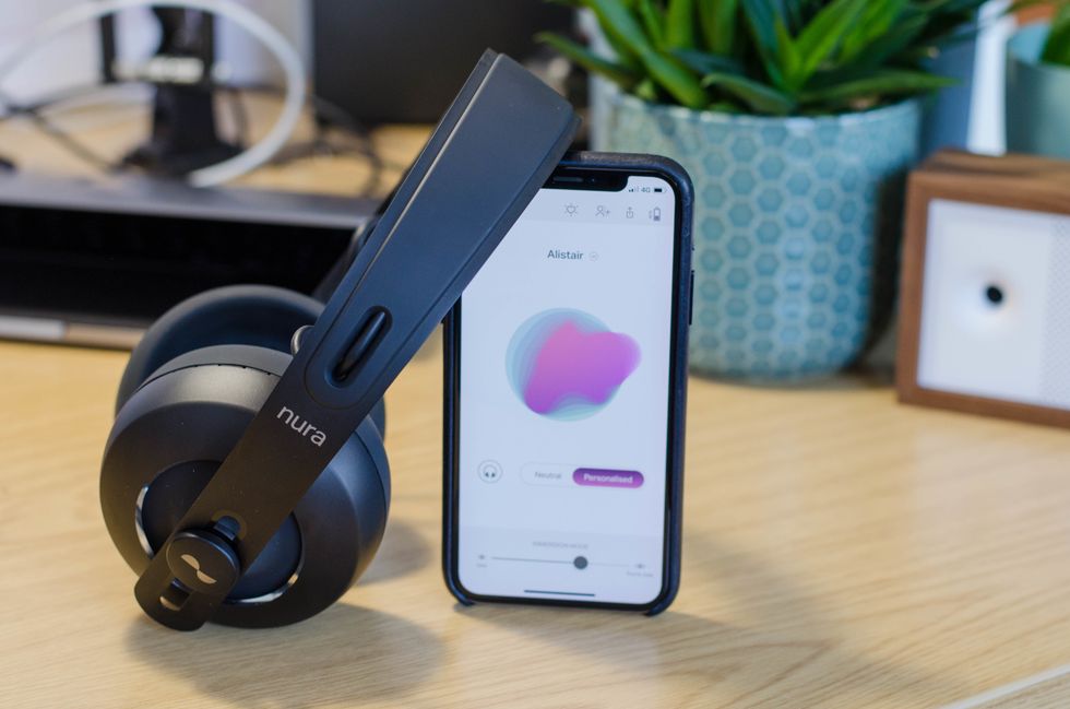 A pair of headphones leaning against a smartphone