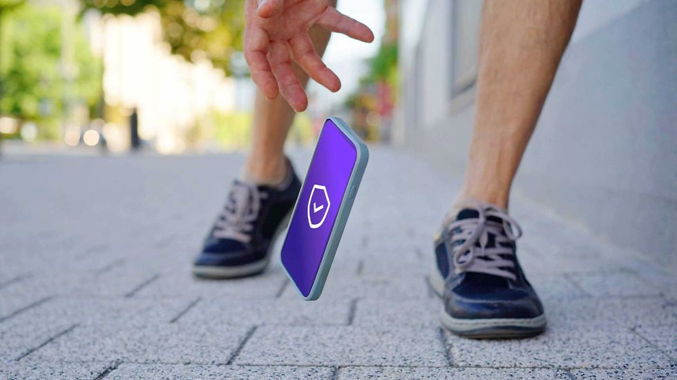 a person dropping their smartphone on the sidewalk