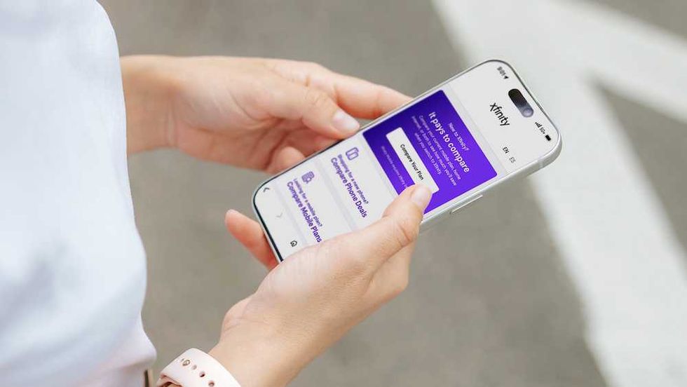 a person holding a cellphone with Xfinity app opened.