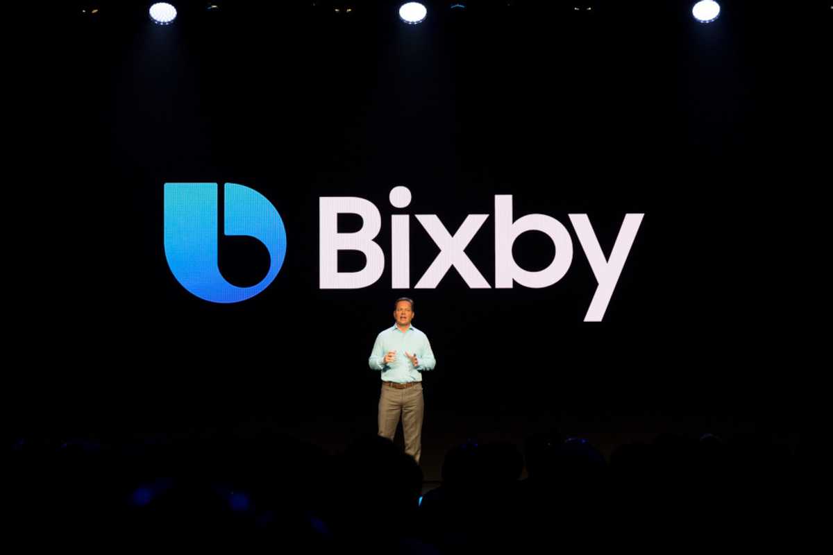 a person standing in front of a Bixby logo on stage