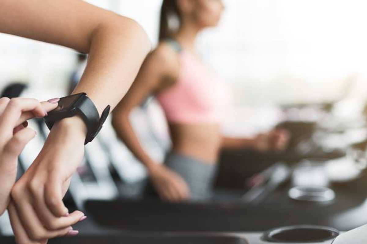 A person with a smartwatch on their arm in the gym