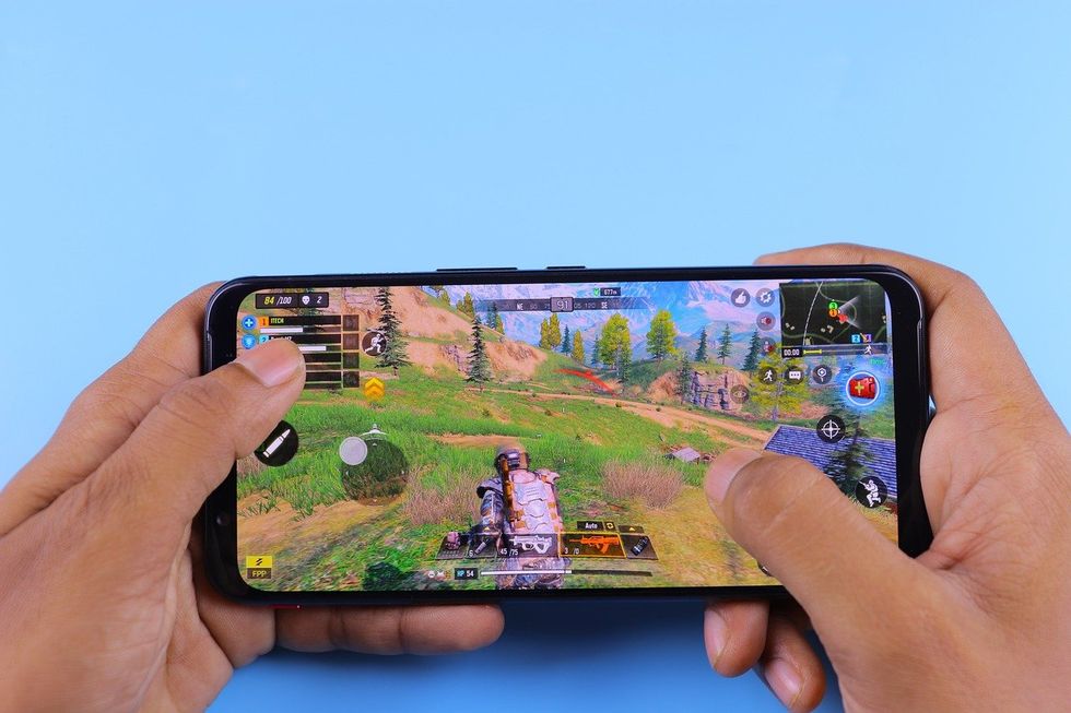 a photo fromm Pixabay of a person playing video game on their smartphone