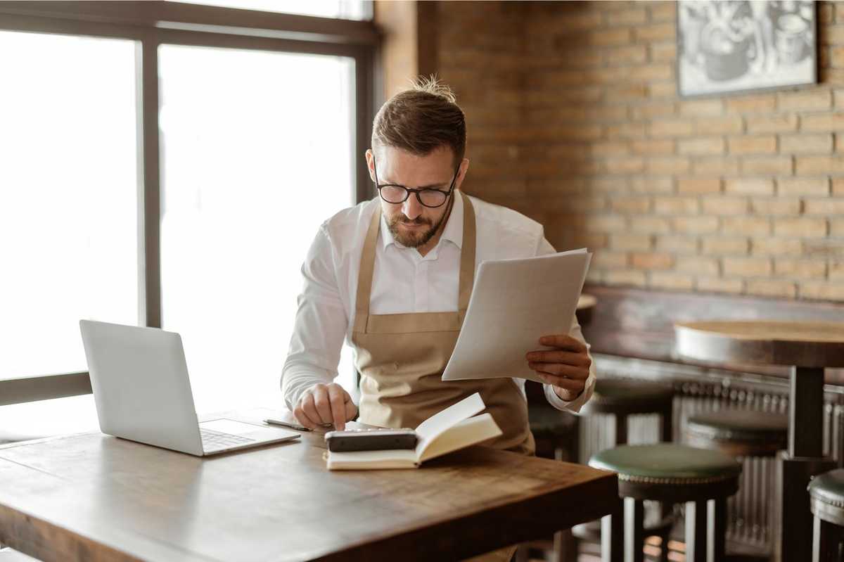 a photo of a business owner on his laptop looking at loan applications