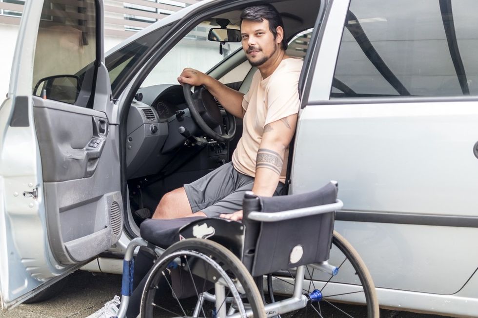 a photo of a disable man getting into a car