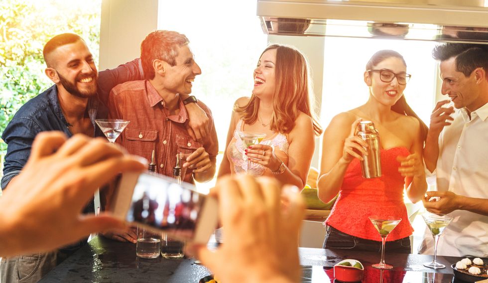 a photo of a group of young adults drinking at a bar
