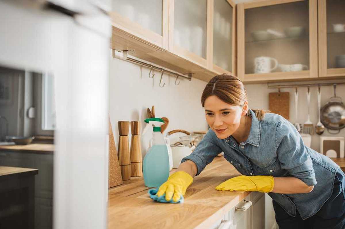 a photo of a Hoomeaglow person cleaning the counter in a kitchen