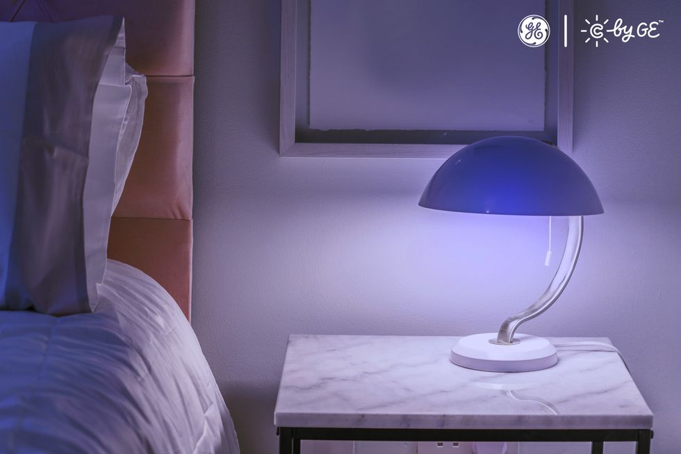 a photo of a lamp with C by GE light bulb on a nightstand.