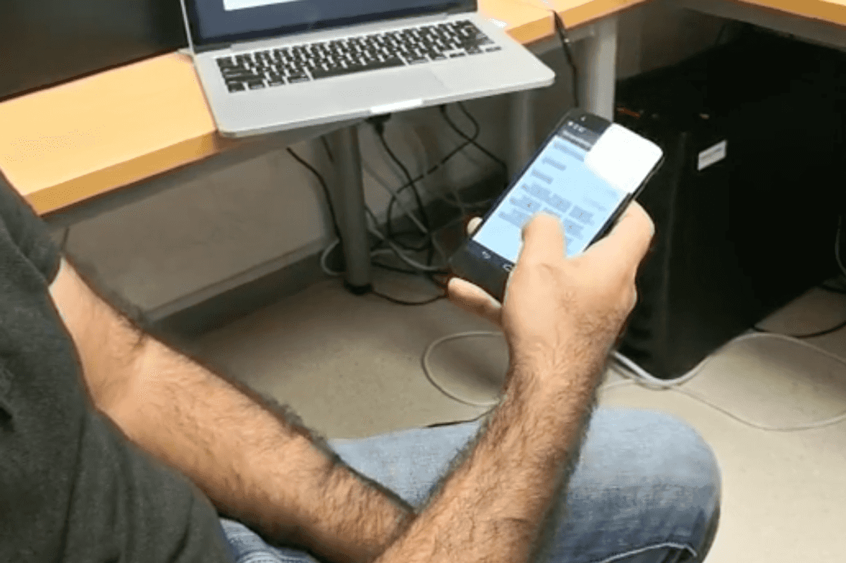 a photo of a man on. his smartphon entering a pin code