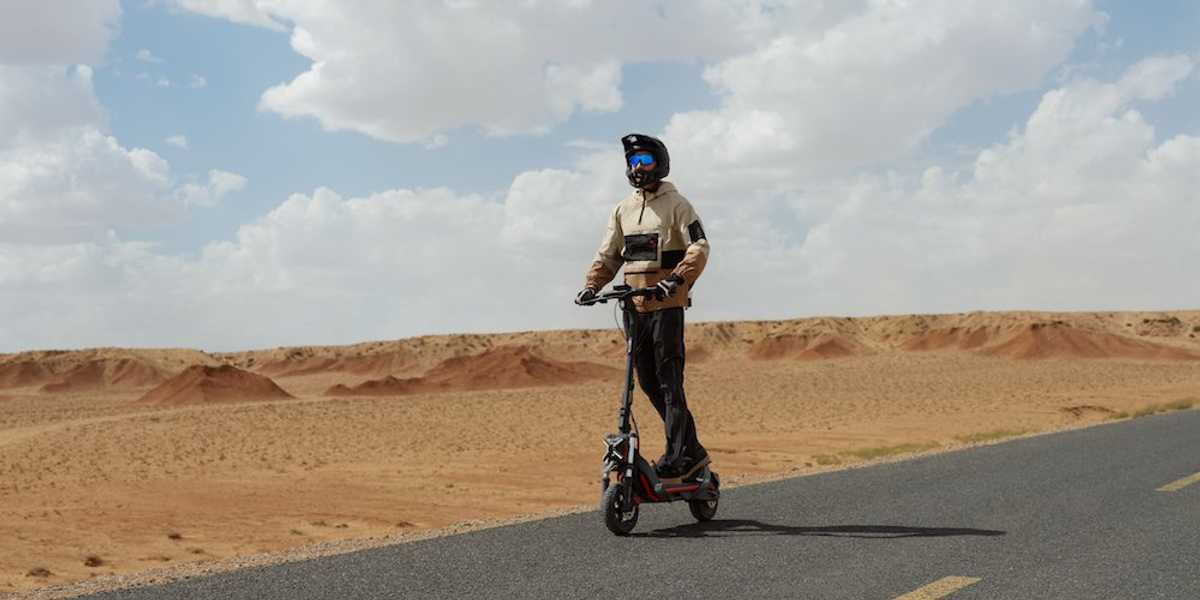 a photo of a man riding a Segway ZT3 Pro All-Terrain eKickScooter on the road