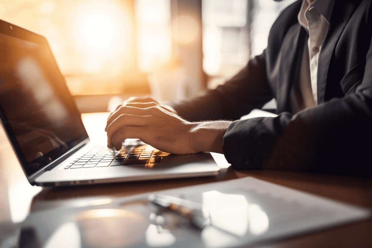 a photo of a man working on a laptop at a desk