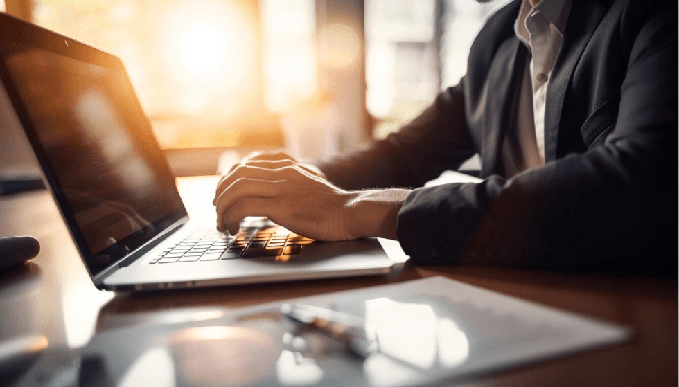 a photo of a man working on a laptop at a desk