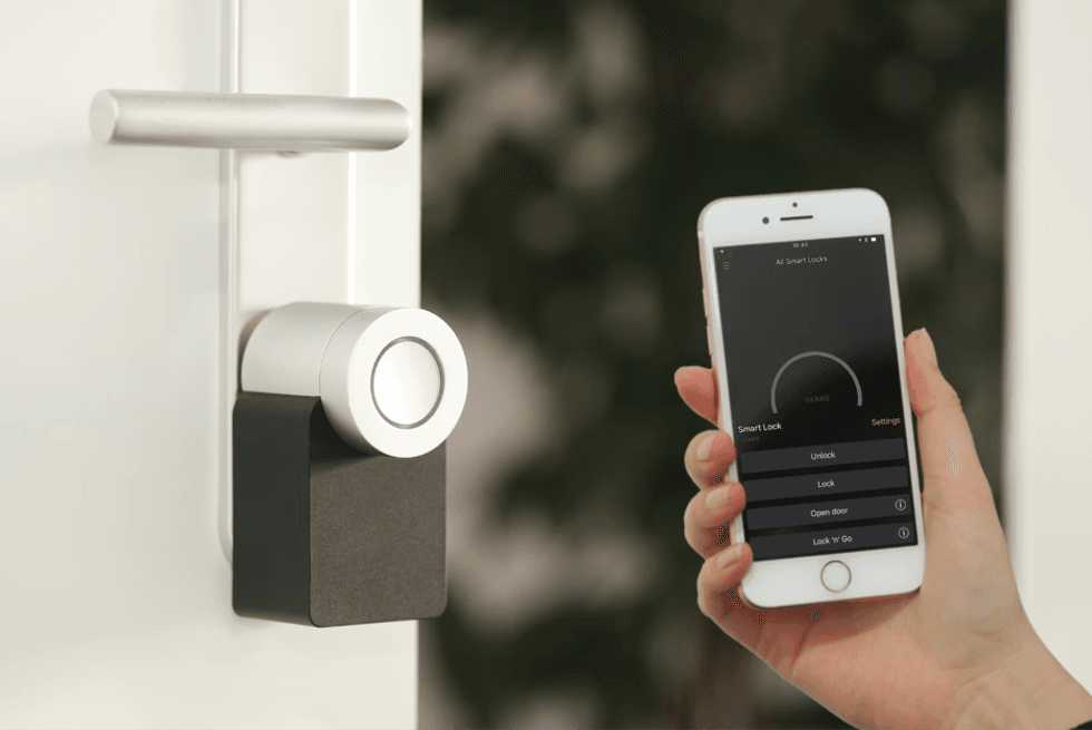 a photo of a Nuki Smart Lock and smartphone using Nuki app to unlock the smart lock.