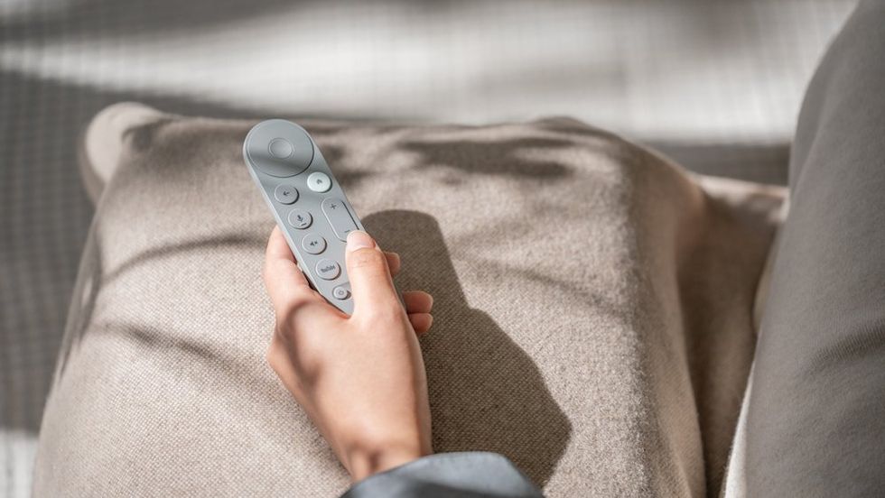 a photo of a person holding the Google TV Streamer remote.