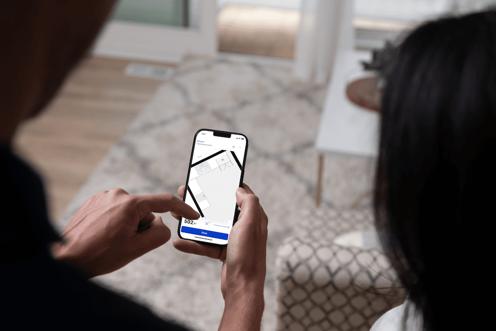 a photo of a person using Mylow on their smartphone to create a room in the app