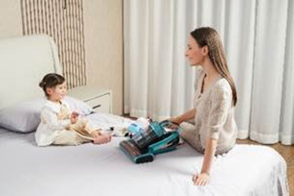 -a photo of a woman and little girl on the bed with Jimmy vacuum