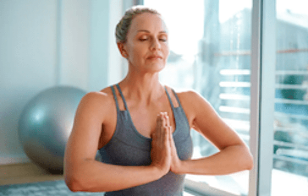 A photo of a woman meditating, which mom can do if you buy her a subscription to the Calm app