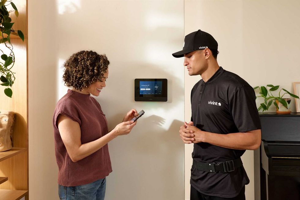 a photo of a woman speaking with a Vivint installer infront of Vivint Smart Home hub