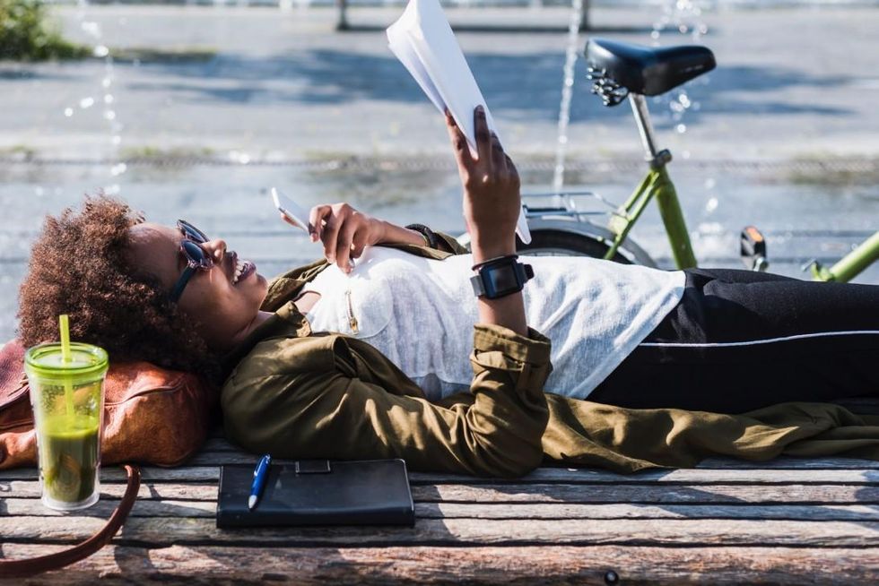 a photo of a woman transcribing a document on a park bench using Descript