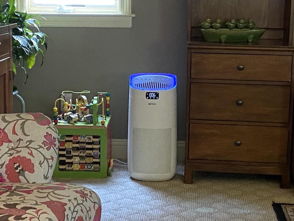 a photo of Afloia Smart Air Purifier in a room with UV-C light on