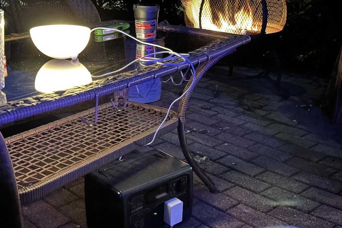 a photo of BLUETTI EB55 Portable Power Station outside powering a smart light