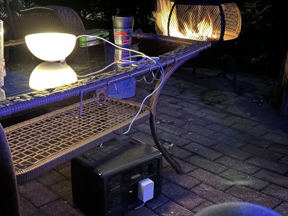 a photo of BLUETTI EB55 Portable Power Station outside powering a smart light