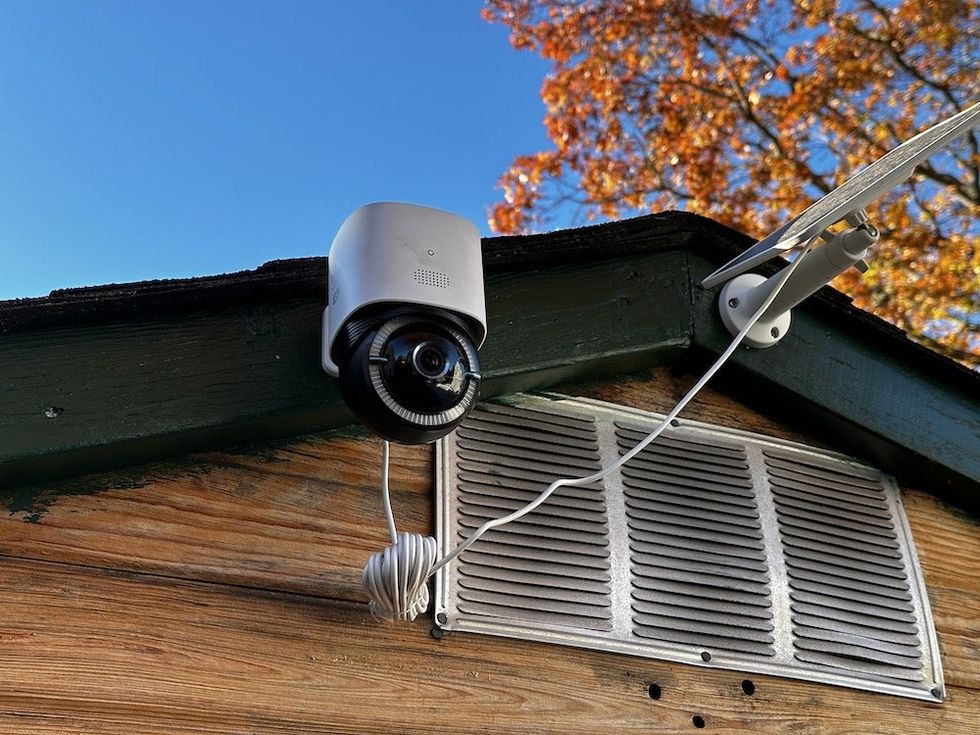 a photo of eufy 4G LTE Cam S330 camera installed outside and connected to a solar panel.