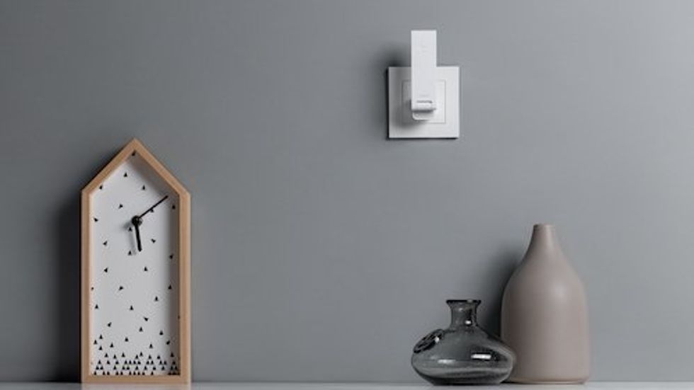 a photo of Hub M100 plugged into an outlet on a wall