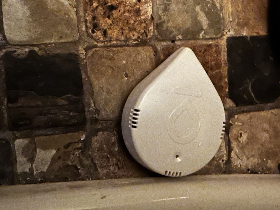 a photo of Moen Smart Leak Detector on the floor next to a toilet