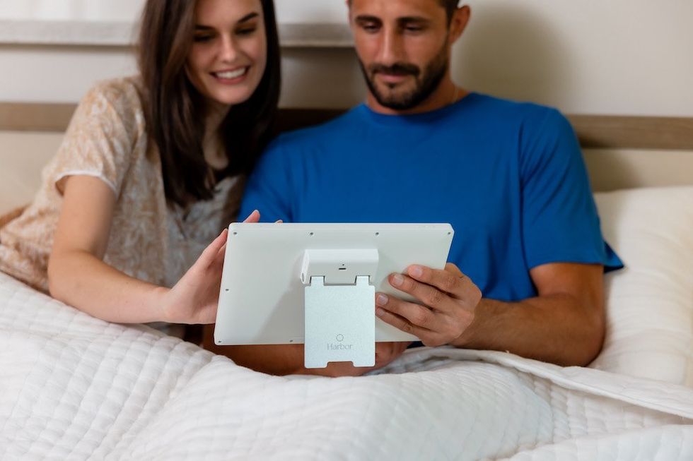 a photo of parents in bed looking at Harbor monitor