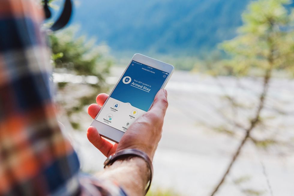 A photo of the ADT Command security system on a mobile device, which can be accessed through a remote app, and even pull up live video