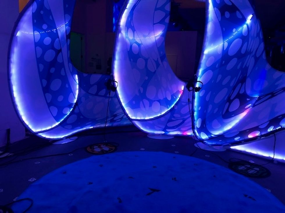 A photo of the virtual reality experience, "Drop in the Ocean," where you float atop a jellyfish