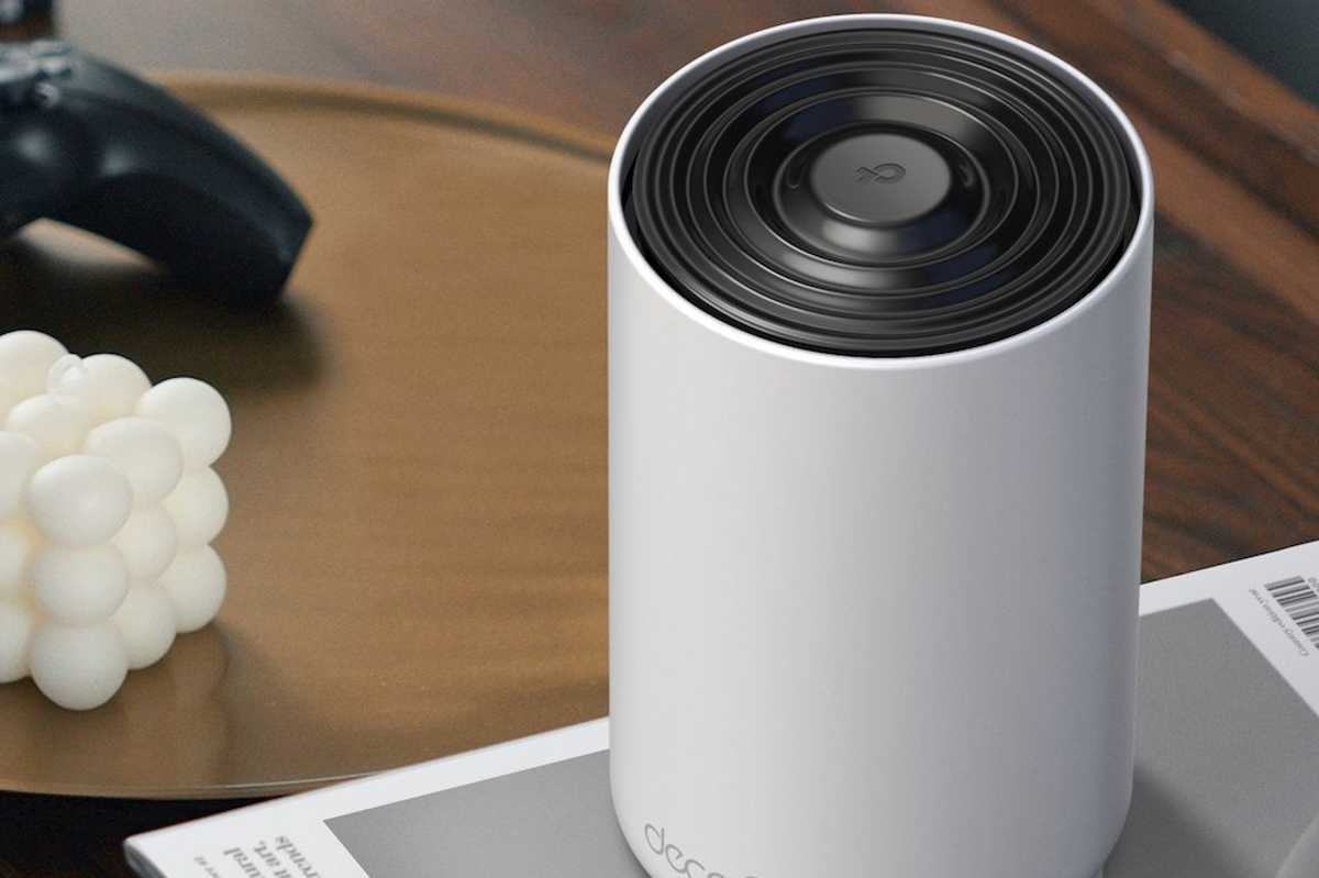 a photo of TP-Link Deco XE70 Pro AXE4900 Tri-Band Wi-Fi 6E Mesh System on a book on a desk.