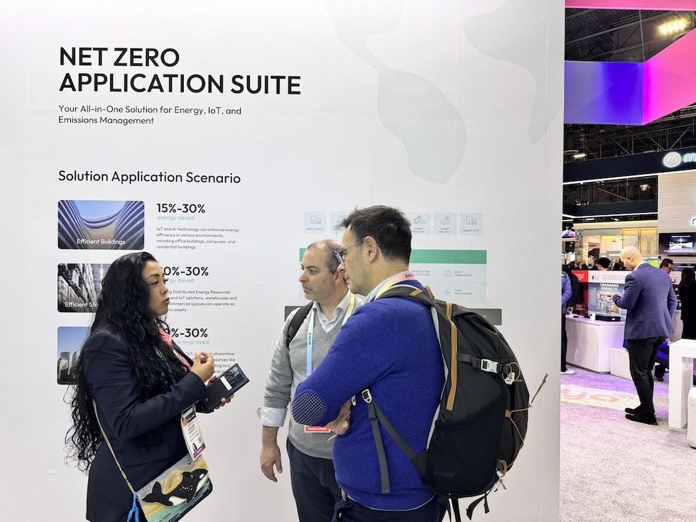 a photo of Tuya executive speaking with CES Show 2024 attendees in their booth.