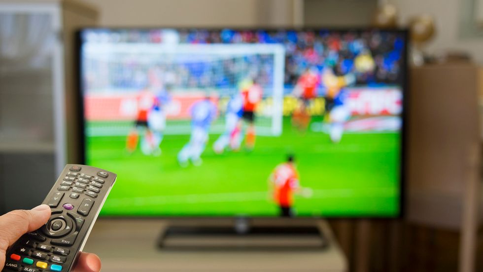a photo of tv remote with tv showing fifa soccess game