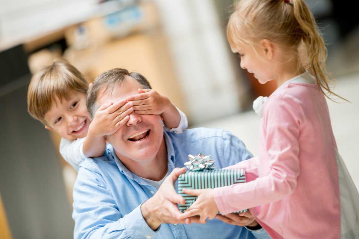 a photo of two children giving their Dad his Father's Day gift.