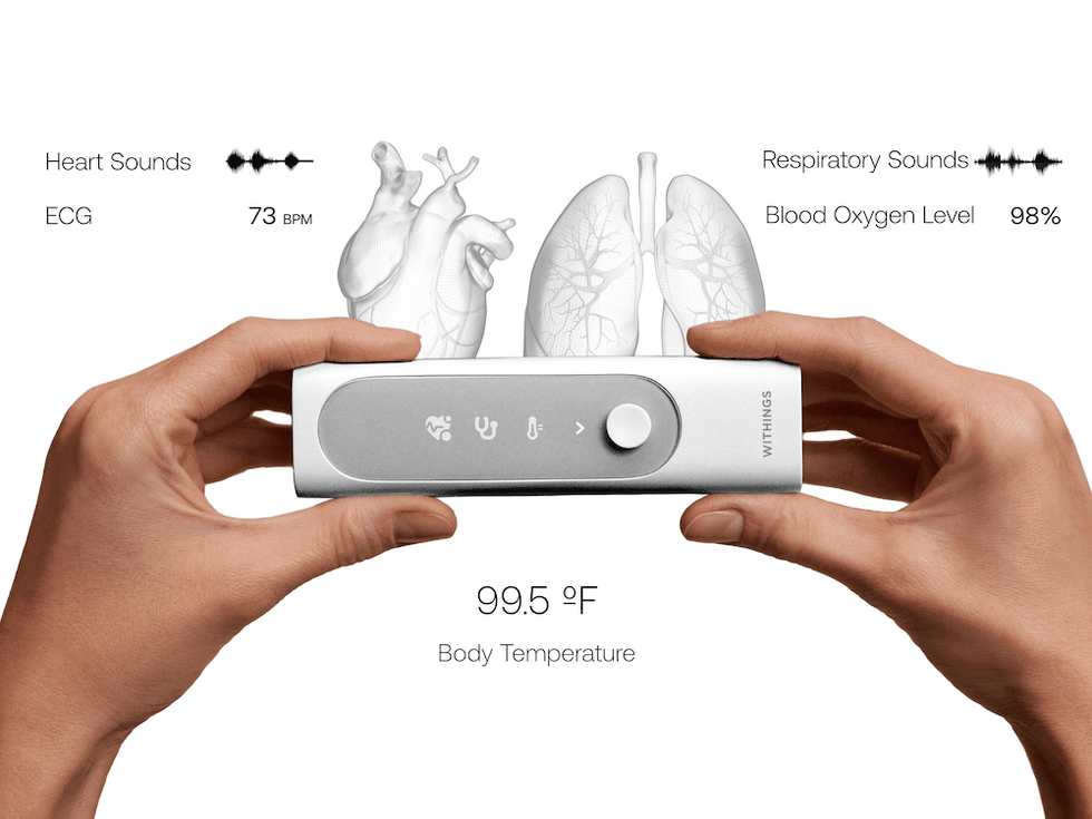 a photo of two hands holdiing a Withings BeamO device