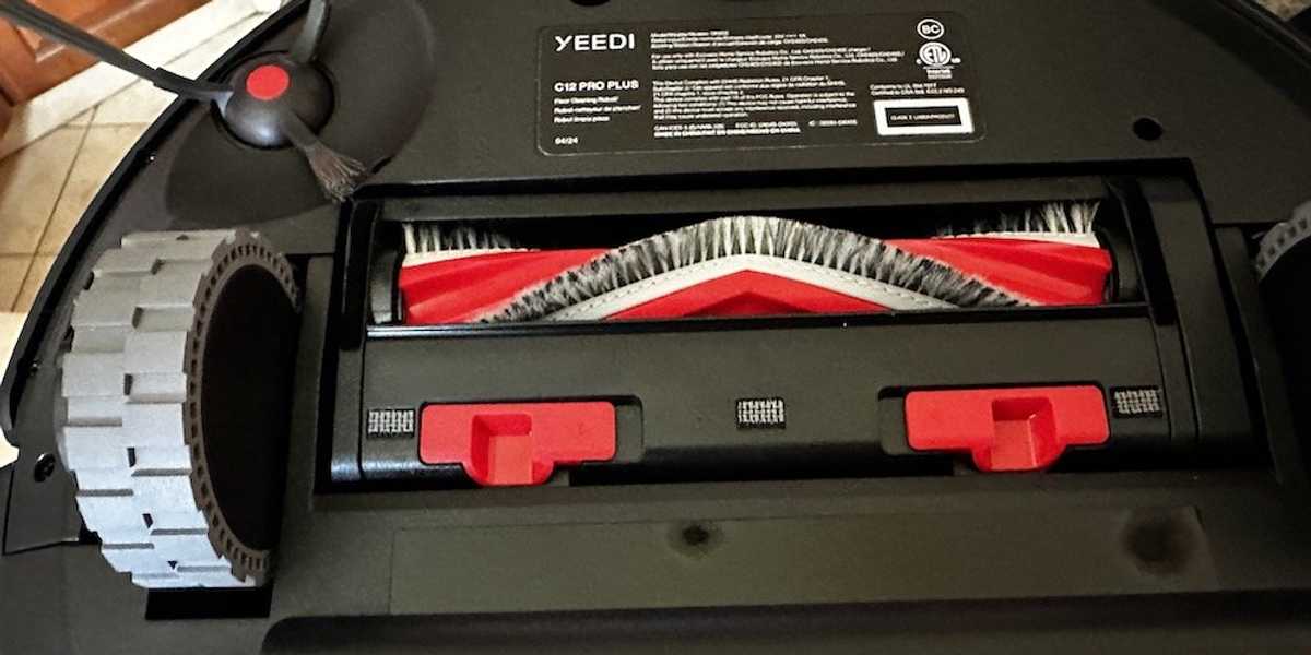 a photo of underneath the Yeedi C12 Pro Plus robot vacuum exposing the unique v-shaped roller brush.