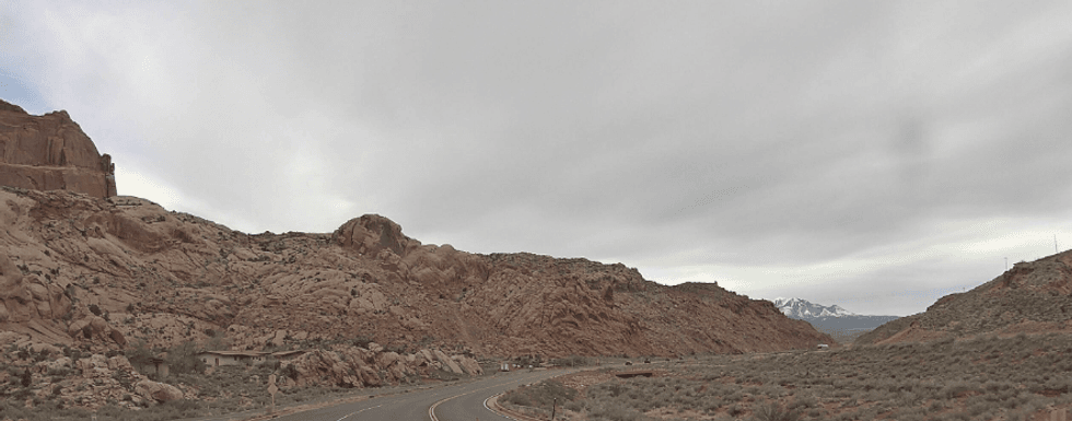 A photo of Utah's red rocks at the entrance to Arches National Park, with snow-capped Mt. Waas in the distance