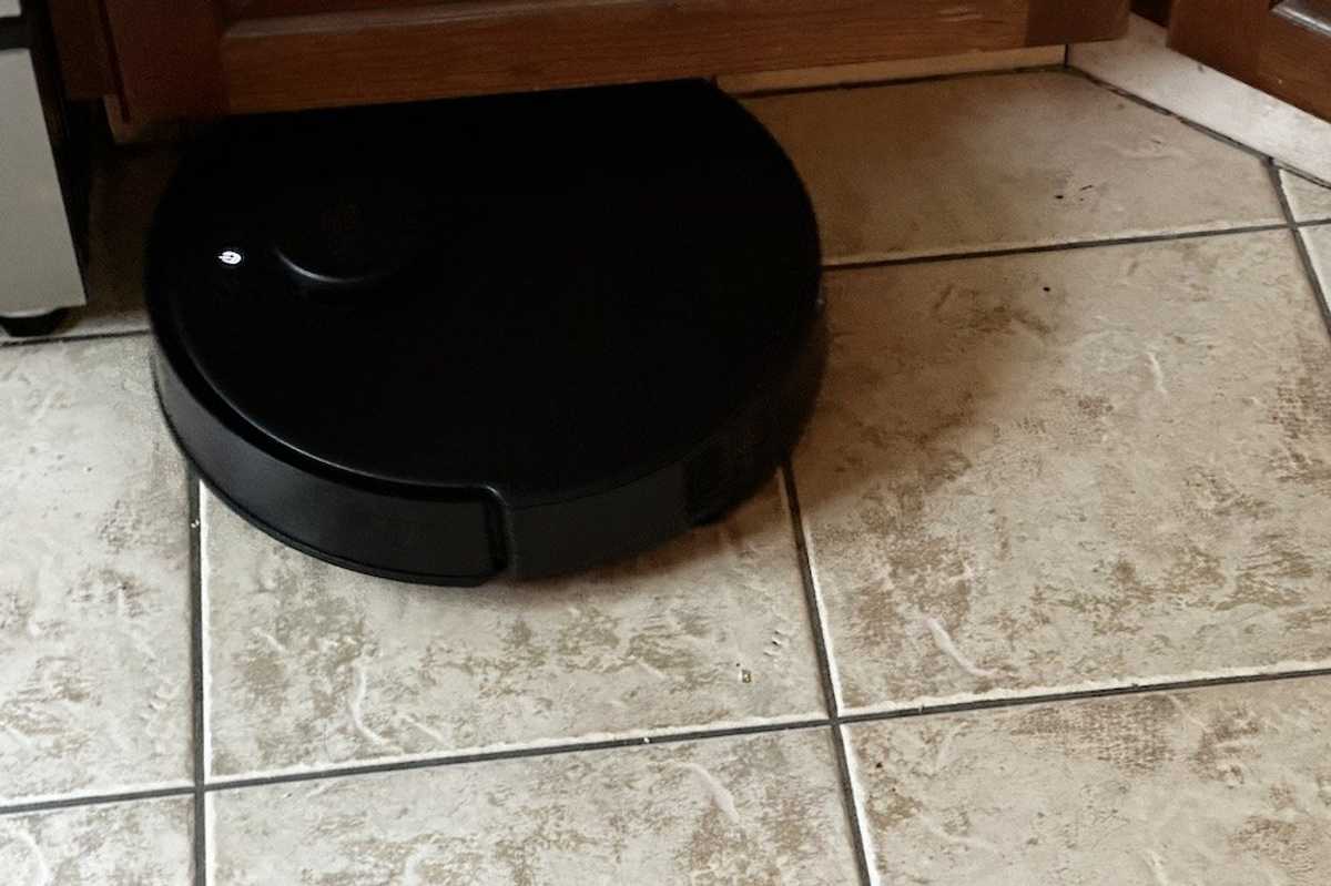 a photo of Yeedi C12 Pro Plus cleaning underneath a cabinet