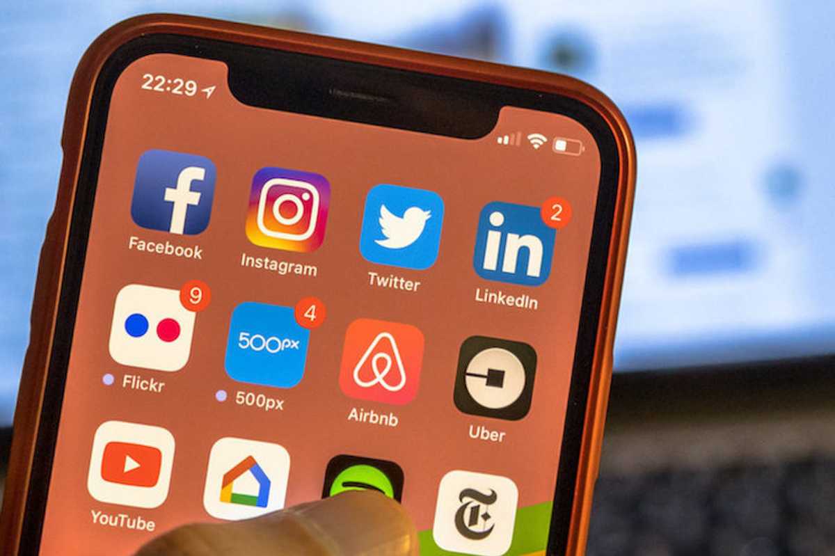 A smartphone with social media apps displayed including Twitter